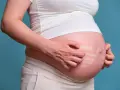 Pancia di donna incinta che si gratta, mostrando segni di prurito in gravidanza.