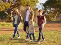 Famiglia felice passeggia nel parco, godendosi il **tempo di qualità** insieme.