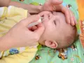 Mani che aiutano un neonato a liberare il naso dal muco, evitando il soffocamento.