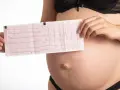 Donna incinta mostra un elettrocardiogramma, preoccupata per la tachicardia in gravidanza.