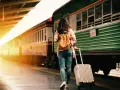 Donna con zaino e trolley in stazione, pronta a cambiare vita a 30 anni.