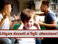 Bambino con le mani sulle orecchie mentre i genitori litigano davanti a lui. Un monito: litigare davanti ai figli può essere dannoso.
