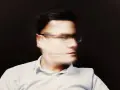 Uomo con occhiali, volto sfocato, espressione pensierosa, forse una crisi mezza età uomo.