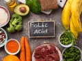 Alimenti ricchi di acido folico, essenziale per la gravidanza: fegato, verdure a foglia verde, legumi, frutta e cereali.