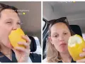 Donna incinta morde un limone intero, soddisfando una strana voglia.