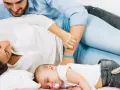 Un neonato dorme sereno tra i genitori. Un momento di pace, un nuovo inizio, quando si ricomincia a vivere dopo un figlio.