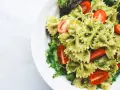 Deliziosa pasta fredda per bambini, con farfalle al pesto e pomodorini freschi, un piatto colorato e gustoso.