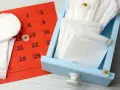 Calendario rosso con cerchiato il 14, assorbenti e fiori di campo. Nessun segno di sangue durante ovulazione incinta.