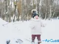 Bambino in montagna, con cappello di lana e guanti, immerso nella neve. Un'avventura invernale per i più piccoli.