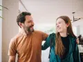 Un padre e una figlia, uniti da un sorriso, si guardano con affetto. La loro complicità è palpabile, un legame forte che supera ogni distanza.