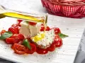 Un piatto di pomodorini confit con robiola, perfetto per una gravidanza sana e gustosa. Olio d'oliva versato su una fetta di pane con formaggio.