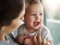 Bambino sorridente con mamma, forse è l'inizio della lallazione.