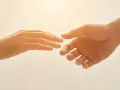 Due mani si tendono l'una verso l'altra, un gesto che può simboleggiare il superamento della differenza tra ansia e paura, trovando conforto.