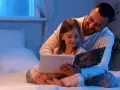 Padre troppo attaccato alla figlia legge un libro con lei a letto, avvolgendola in un abbraccio protettivo.