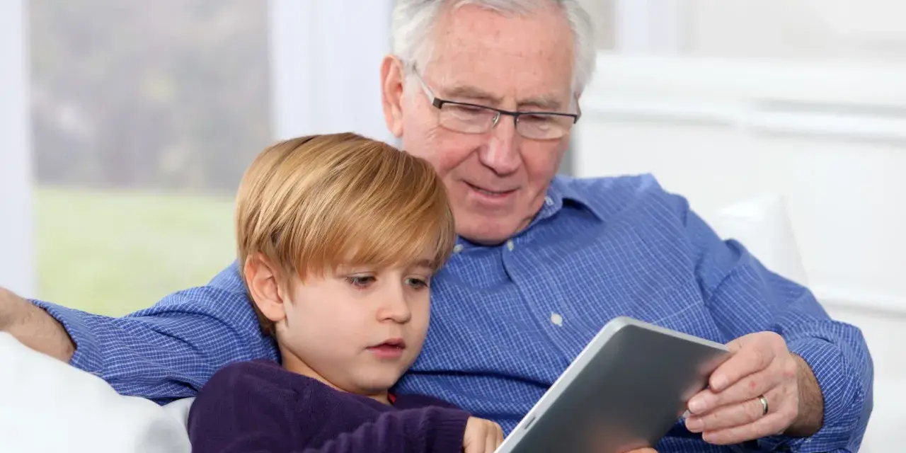 Nonni che non aiutano, ma osservano il nipote giocare sul tablet.