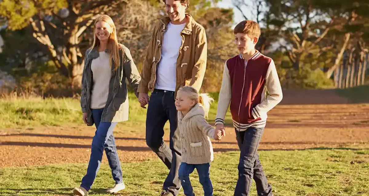 Famiglia felice passeggia nel parco, godendosi il **tempo di qualità** insieme.