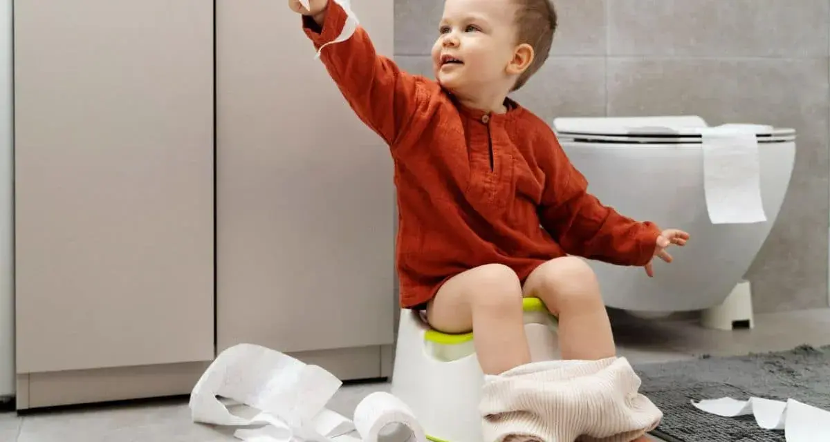Bambino di 4 anni sul vasino, con rotoli di carta igienica sparsi. Un piccolo disastro, ma un grande passo verso l'indipendenza!
