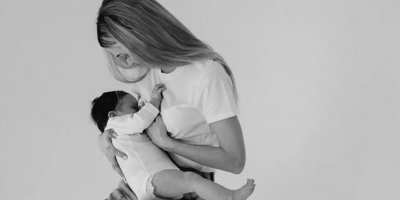 Madre con neonato in braccio, un momento intimo di allattamento. Non c'è traccia di fumare in allattamento, solo amore e cura.
