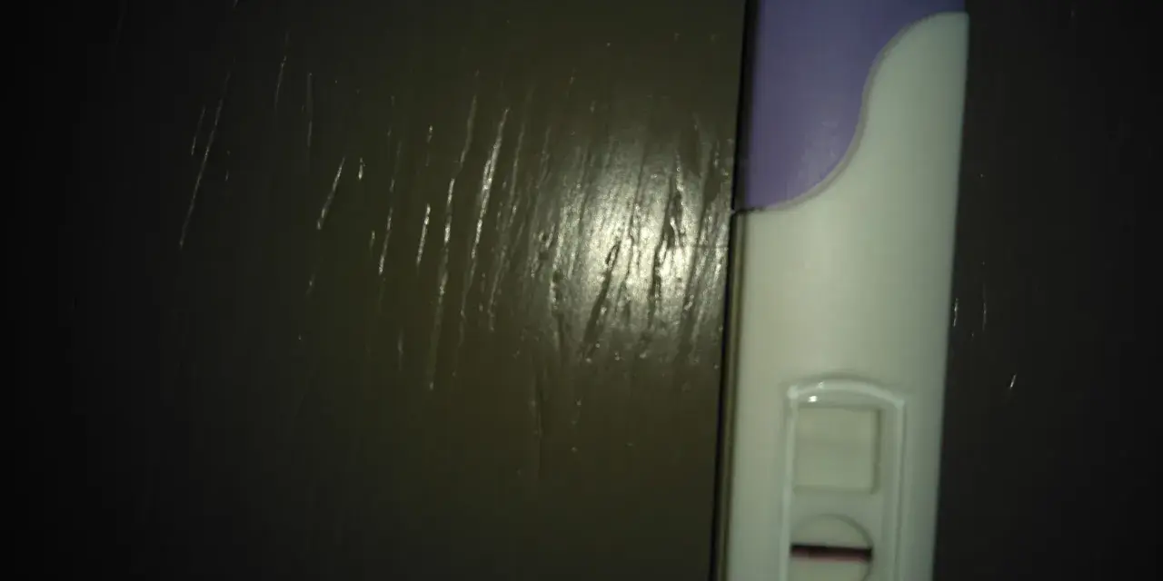 Test di gravidanza con una linea sottile, quasi un ghost line, che lascia un dubbio.