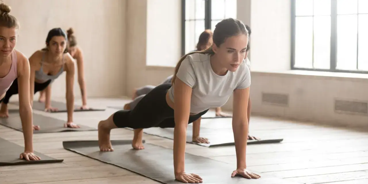 Donne in posizione di plank durante una lezione di pilates in gravidanza.