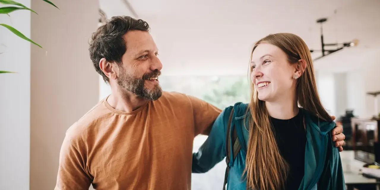 Un padre e una figlia, uniti da un sorriso, si guardano con affetto. La loro complicità è palpabile, un legame forte che supera ogni distanza.
