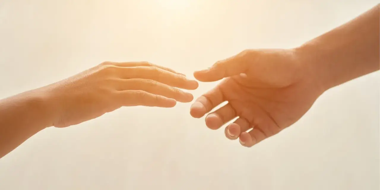 Due mani si tendono l'una verso l'altra, un gesto che può simboleggiare il superamento della differenza tra ansia e paura, trovando conforto.