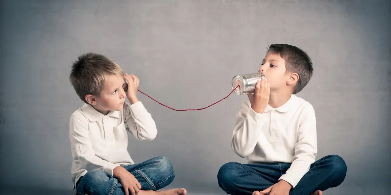 Due bambini comunicano con un telefono di latta. Come mio figlio ha iniziato a parlare a 4 anni, mi immagino che stiano condividendo segreti.