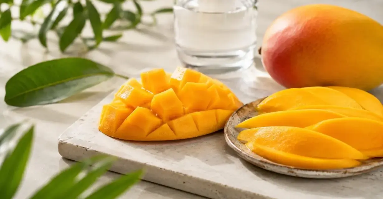 Un succoso mango, tagliato a cubetti e a fette, pronto per essere gustato. Sembra un mango in gravidanza, pieno di dolcezza e vitalità.