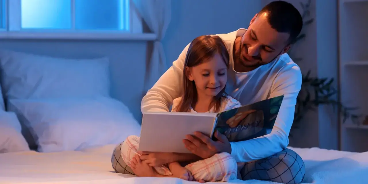Padre troppo attaccato alla figlia legge un libro con lei a letto, avvolgendola in un abbraccio protettivo.