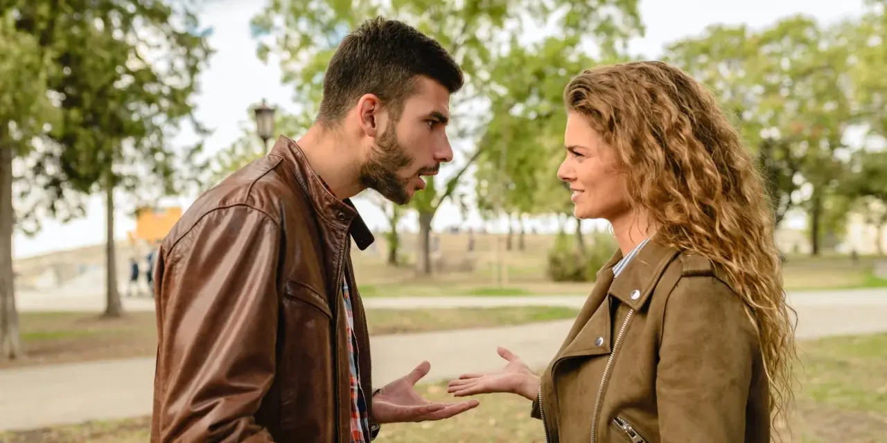 Coppia discute animatamente in un parco. Lui sembra frustrato, lei perplessa, forse per un attaccamento morboso alla famiglia di origine che ostacola la loro relazione.