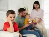 Bambino annoiato, forse per la nascita del fratellino e le conseguenti crisi isteriche. La famiglia è sullo sfondo.