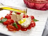 Un piatto di pomodorini confit con robiola, perfetto per una gravidanza sana e gustosa. Olio d'oliva versato su una fetta di pane con formaggio.