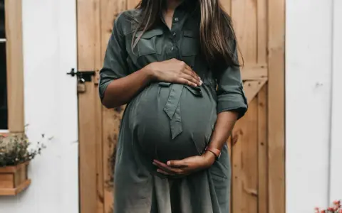 Donna incinta con mani sul pancione, in attesa di un bambino. Un momento di gioia che spesso include l'analisi sangue gravidanza.