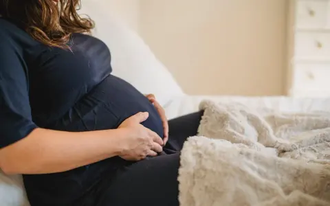 Donna incinta accarezza il pancione, preoccupata per la possibile escherichia coli in gravidanza.