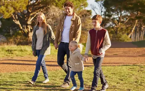 Famiglia felice passeggia nel parco, godendosi il **tempo di qualità** insieme.