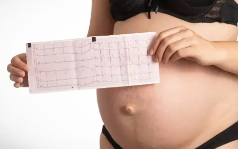 Donna incinta mostra un elettrocardiogramma, preoccupata per la tachicardia in gravidanza.