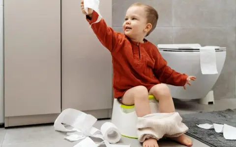 Bambino di 4 anni sul vasino, con rotoli di carta igienica sparsi. Un piccolo disastro, ma un grande passo verso l'indipendenza!