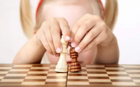 Bambino 3 anni non accetta regole: le sue mani manipolano i pezzi degli scacchi, creando una sua personale partita.
