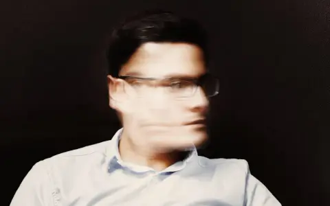 Uomo con occhiali, volto sfocato, espressione pensierosa, forse una crisi mezza età uomo.