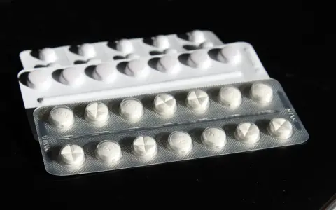 Blister di pillole bianche, alcune con incisione a croce. Potrebbe trattarsi di cardioaspirina in gravidanza, un farmaco da usare con cautela.