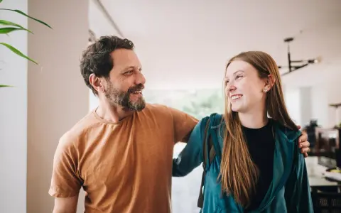 Un padre e una figlia, uniti da un sorriso, si guardano con affetto. La loro complicità è palpabile, un legame forte che supera ogni distanza.