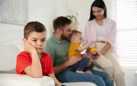 Bambino annoiato, forse per la nascita del fratellino e le conseguenti crisi isteriche. La famiglia è sullo sfondo.