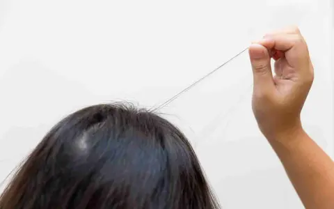 Un neonato si tira i capelli, un gesto curioso e un po' dispettoso.