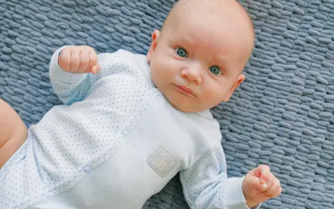 Un bimbo con occhi azzurri, un riflesso di moro autismo, gioca sul tappeto.