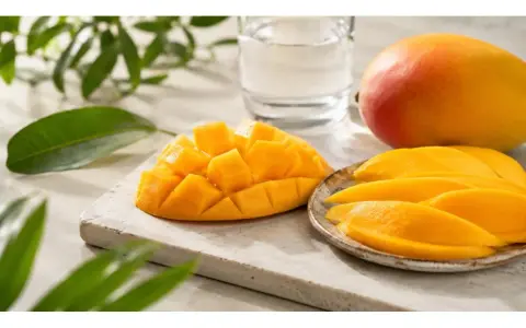 Un succoso mango, tagliato a cubetti e a fette, pronto per essere gustato. Sembra un mango in gravidanza, pieno di dolcezza e vitalità.