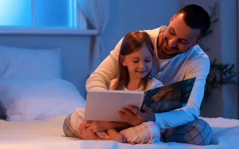 Padre troppo attaccato alla figlia legge un libro con lei a letto, avvolgendola in un abbraccio protettivo.