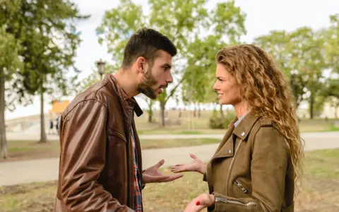 Coppia discute animatamente in un parco. Lui sembra frustrato, lei perplessa, forse per un attaccamento morboso alla famiglia di origine che ostacola la loro relazione.
