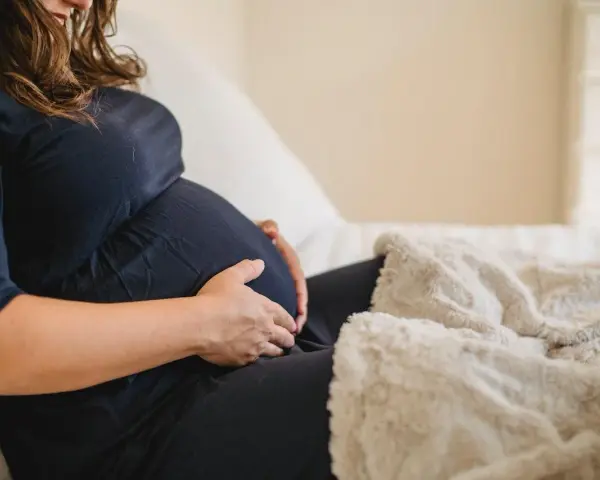 Donna incinta accarezza il pancione, preoccupata per la possibile escherichia coli in gravidanza.