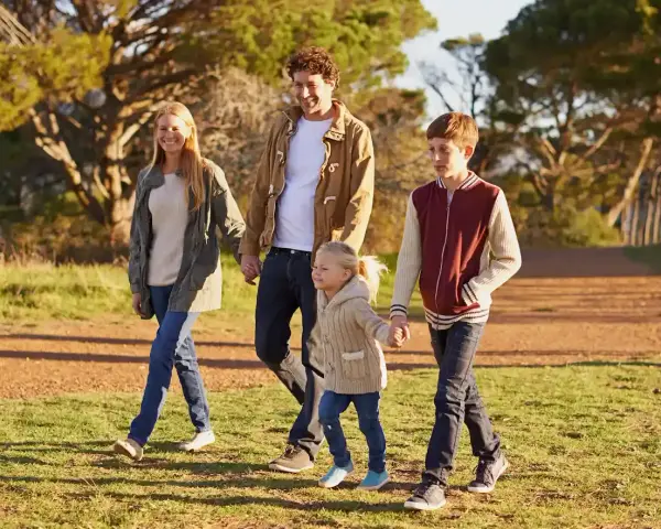 Famiglia felice passeggia nel parco, godendosi il **tempo di qualità** insieme.