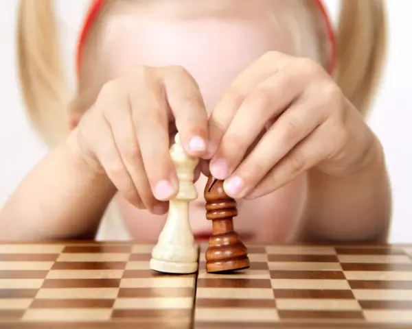 Bambino 3 anni non accetta regole: le sue mani manipolano i pezzi degli scacchi, creando una sua personale partita.